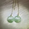 Lustrous green jade 'Prosperity Blooms' earrings with floral design and 14K gold chain, symbolizing wealth and renewal.