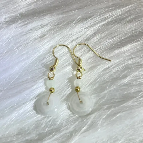 Elegant 'White Jade Safety Buckle Earrings,' with the serene beauty of white jade paired with delicate golden accents, offering a sophisticated accessory that carries deep cultural significance.