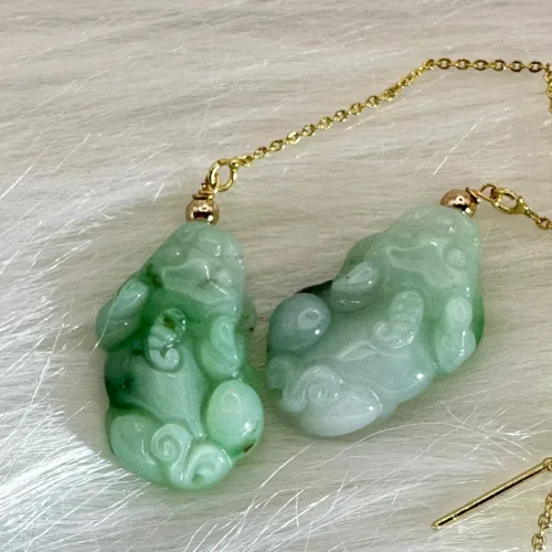 Luminous jade 'Wealth-Inviting Pixiu' earrings with golden accents, designed to beckon fortune and guard assets.