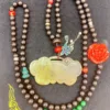 Colorful beaded necklace with jade pendant and floral charm.