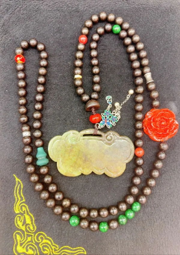 Colorful beaded necklace with jade pendant and floral charm.