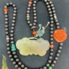 Beaded necklace with jade pendant and floral brooch.