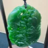 Intricate green jade pi xiu carving on stand.