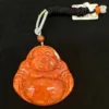 Carved orange Buddha pendant with black cord.