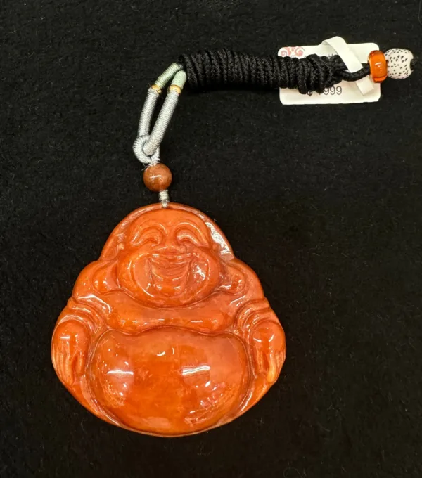 Carved orange Buddha pendant with black cord.