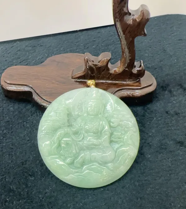 Jade pendant with intricate carving on wooden stand.