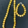 Yellow beaded necklace on dark background.