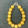 Yellow beaded bracelet on gray background.