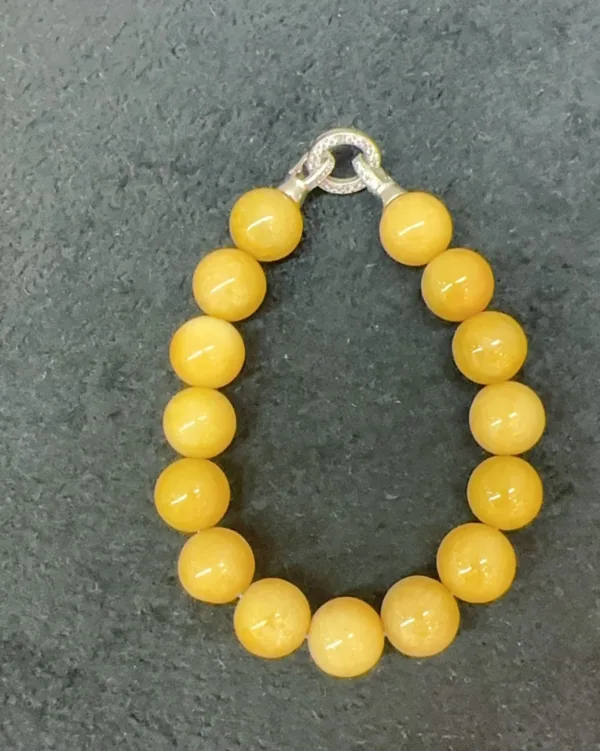 Yellow beaded bracelet on gray background.