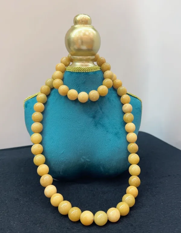 Yellow bead necklace on blue display stand.