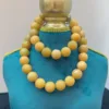 Yellow beaded necklace on blue display stand.