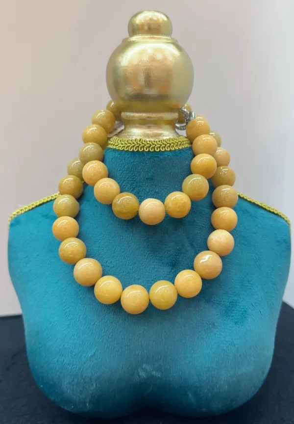 Yellow beaded necklace on blue display stand.