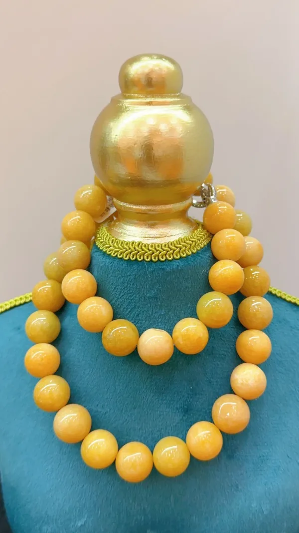 Golden beads necklace on mannequin display.