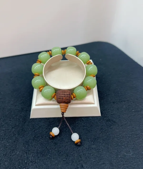 Jade bead bracelet with wooden accents on display.