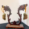 Carved wooden stand displaying jade pendants.