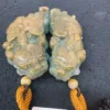 Carved jade dragon pendants with yellow tassels.