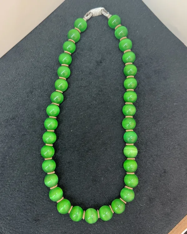 Green bead necklace on black background.