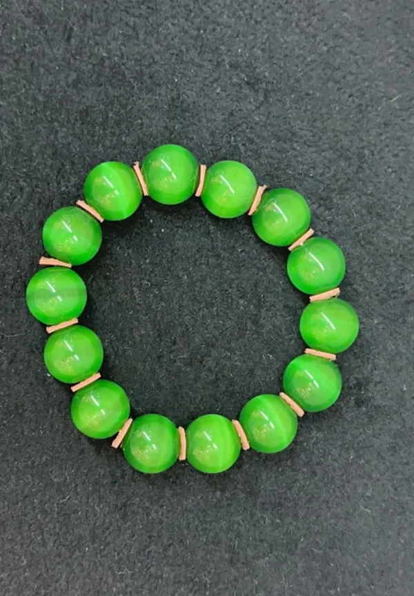 Green bead bracelet on black surface.