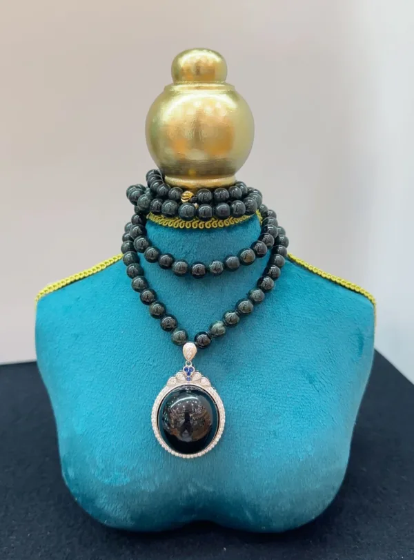Elegant necklace with pendant on blue display stand.