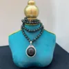 Elegant necklace on teal display stand.