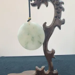 Jade disc on carved wooden wave stand.