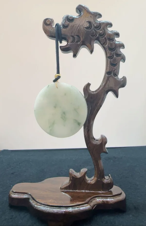 Jade disc on carved wooden wave stand.