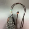 Buddha pendant on braided brown necklace.