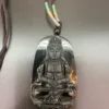 Buddha pendant on necklace with intricate design.