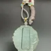 Jade pendant with Chinese inscriptions and decorative tassel.