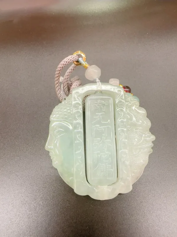 Carved jade pendant with Chinese inscription and cord