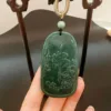 Carved jade pendant held by hand