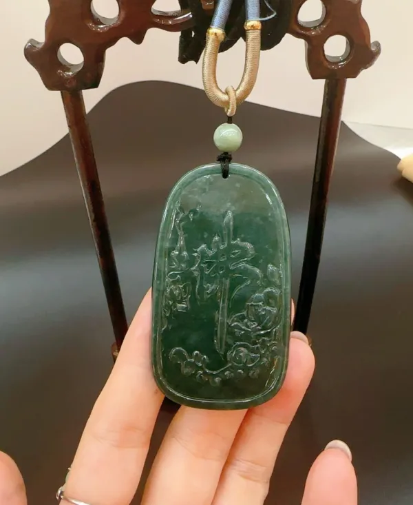Carved jade pendant held by hand