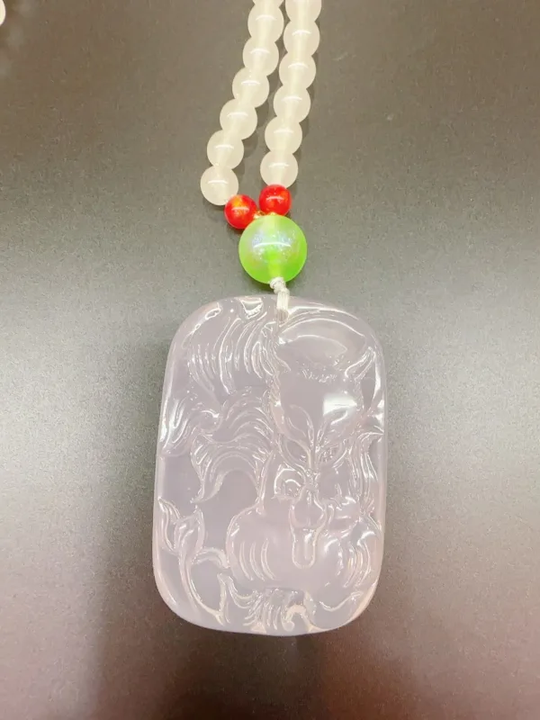 Carved jade pendant with beaded necklace.