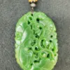 Carved green jade pendant with intricate design.