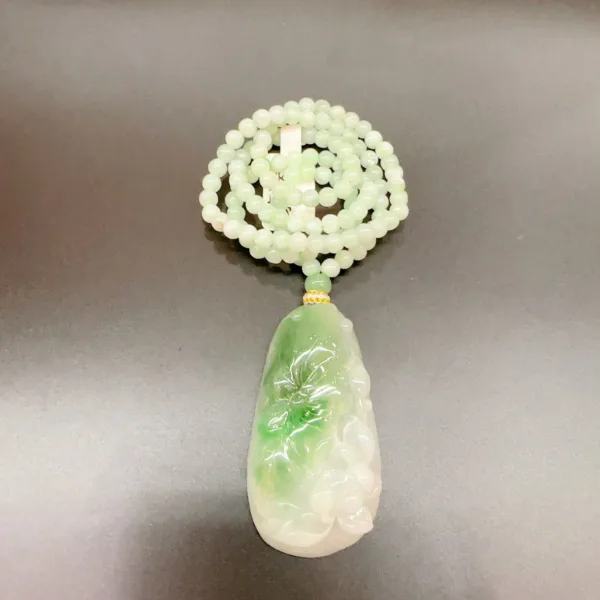 Jade necklace with green pendant on table