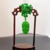 Green jade cicada sculpture on wooden stand.