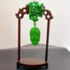 Jade cicada carving on wooden display stand.