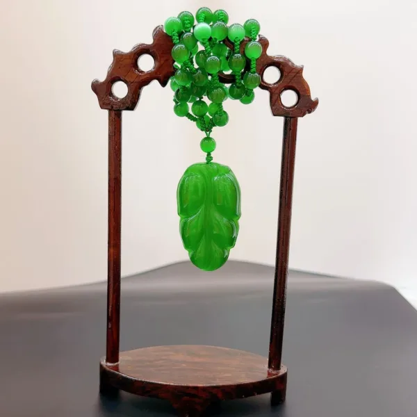 Jade cicada carving on wooden display stand.