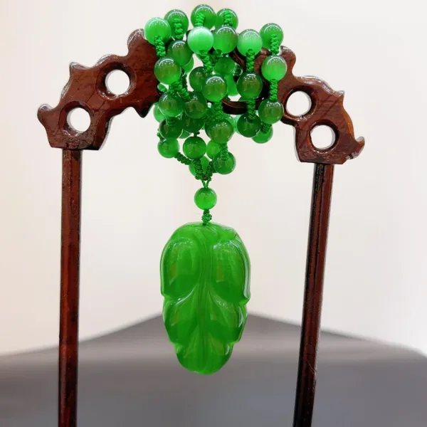 Jade hairpin with intricate green beads and carved design.