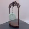 Carved wood stand displaying jade disc.