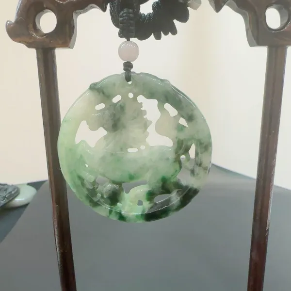 Jade pendant on wooden stand.