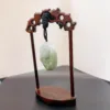 Carved jade pendant on wooden display stand.