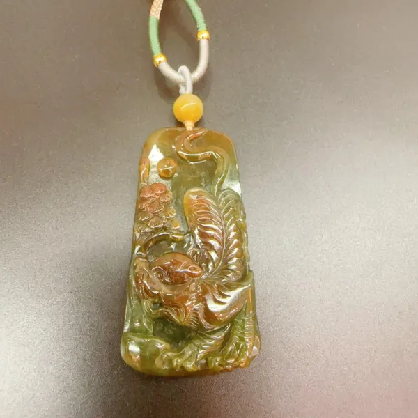 Carved jade pendant with decorative cord.