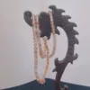 Pearl necklace on wooden jewelry stand.