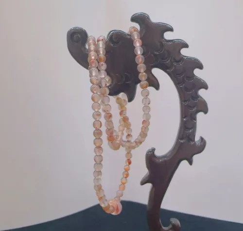 Pearl necklace on wooden jewelry stand.