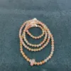 Pink pearl necklace on gray background.