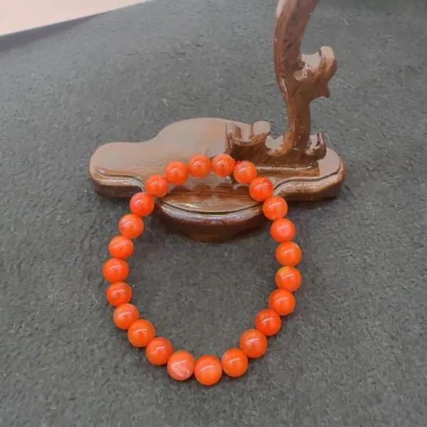 Orange bead bracelet on wooden display