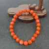 Orange bead bracelet on wooden display