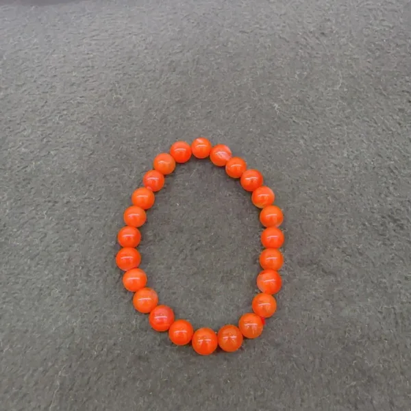 Orange bead bracelet on gray background.