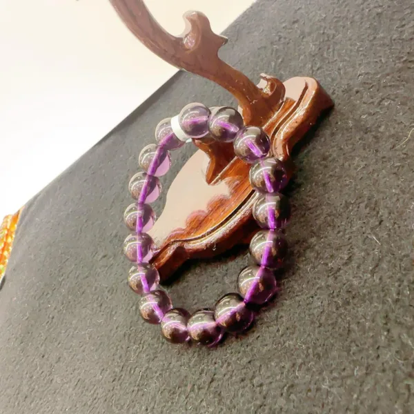 Purple bead bracelet on wooden anchor decoration.